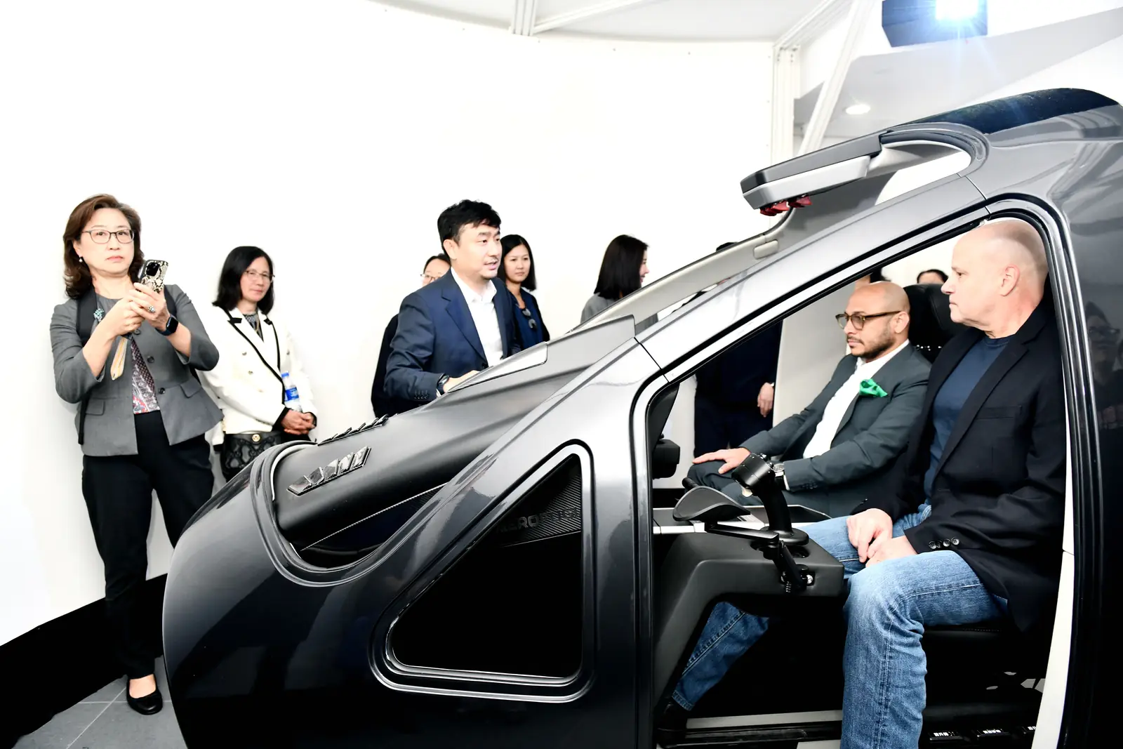 Participants sit in an eVTOL aircraft cockpit during a company visit