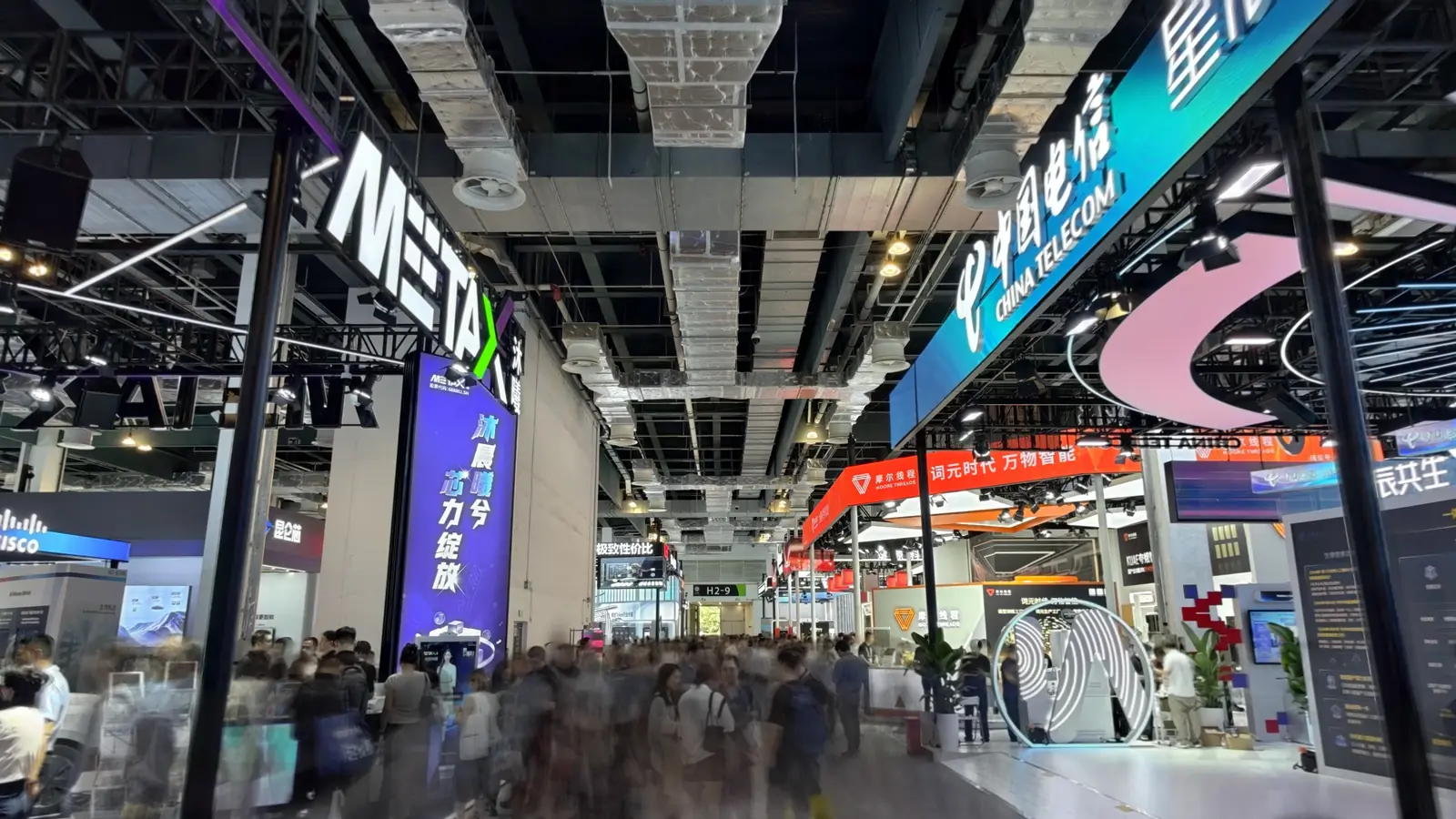 Busy exhibition hall with large brand displays