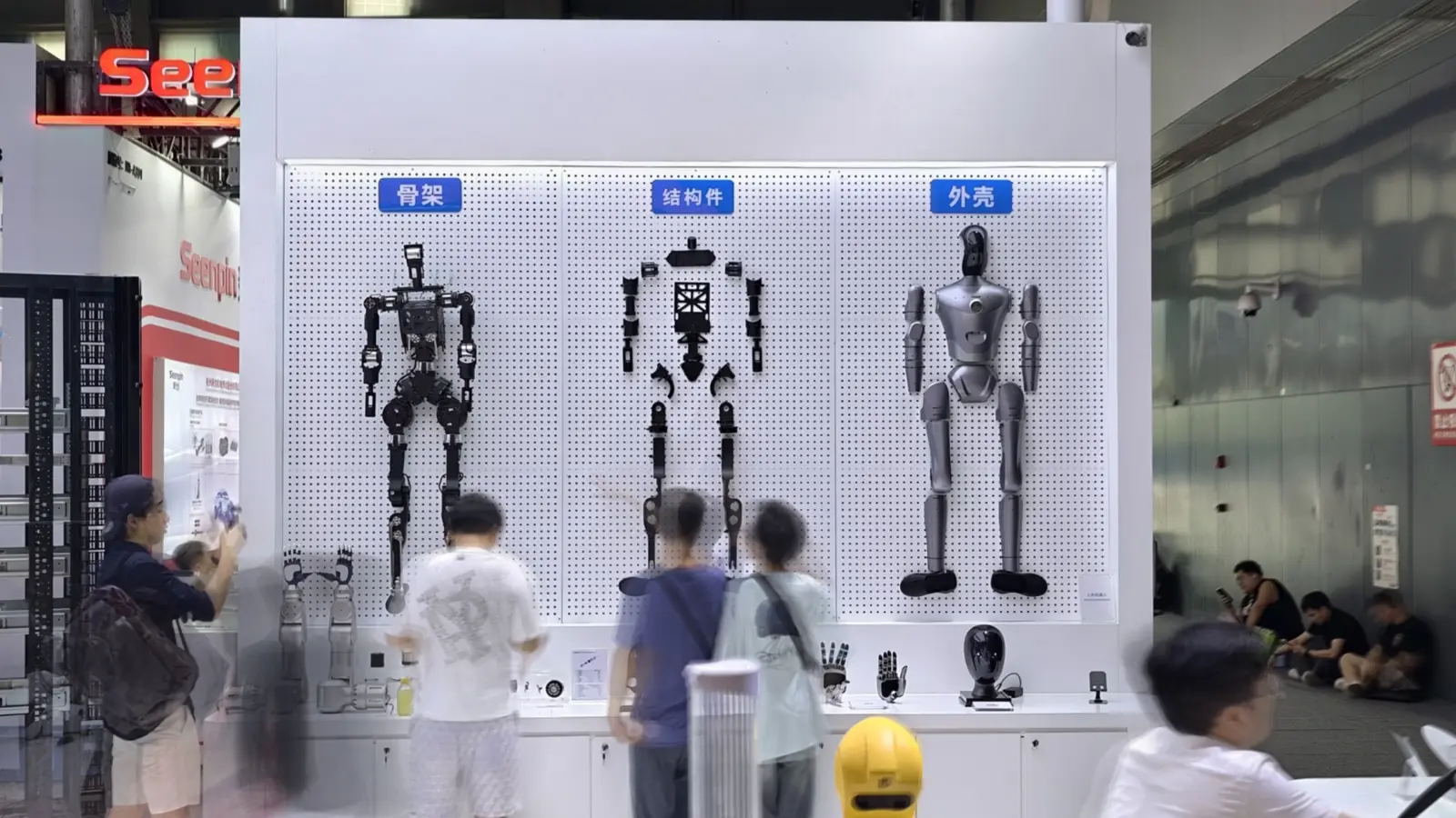 Visitors view a wall of humanoid robot models