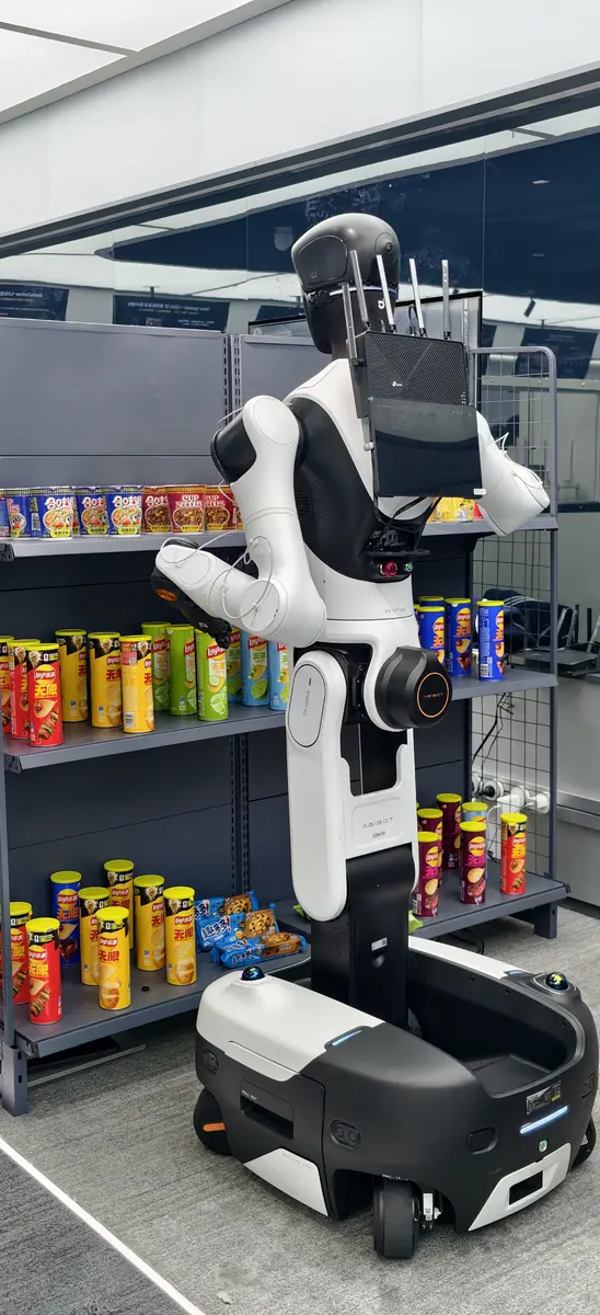 A wheeled humanoid robot stocking shelves in a retail demo
